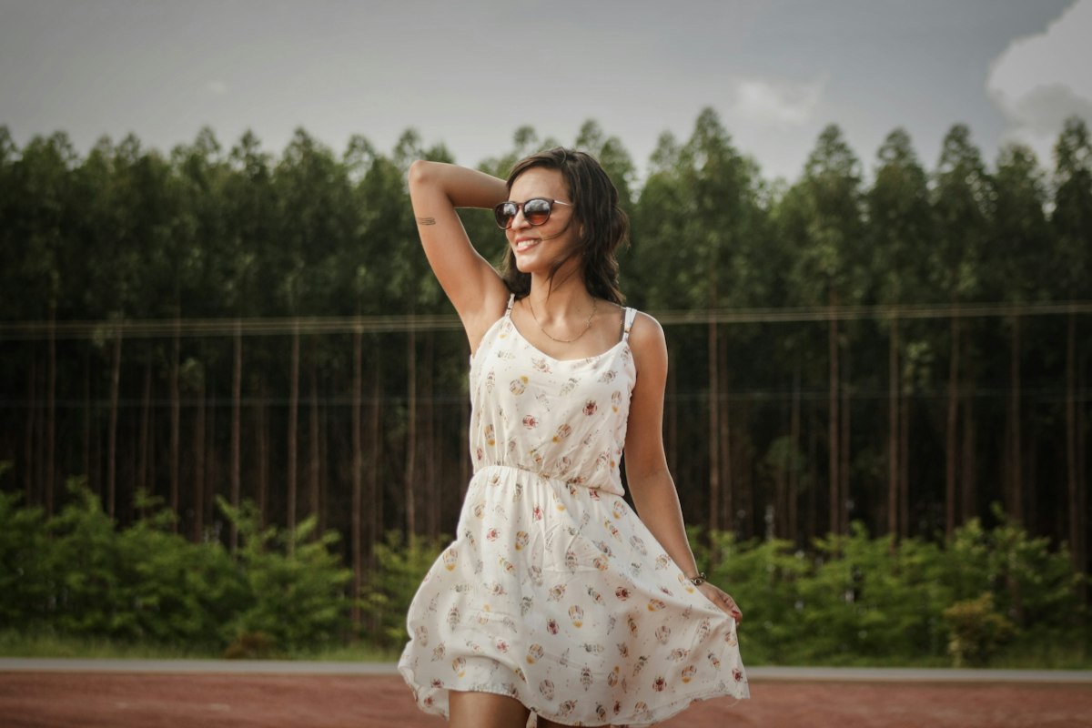 Woman touching her hair, soft casual portrait suitable for a lightweight camisole top — placeholder image
