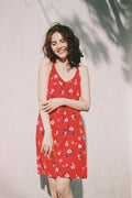 Woman in a relaxed, minimal-style dress standing against a plain white wall — placeholder image