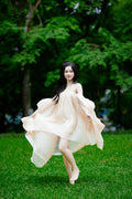 Young woman in a flowing tiered maxi dress in a grassy park — placeholder image
